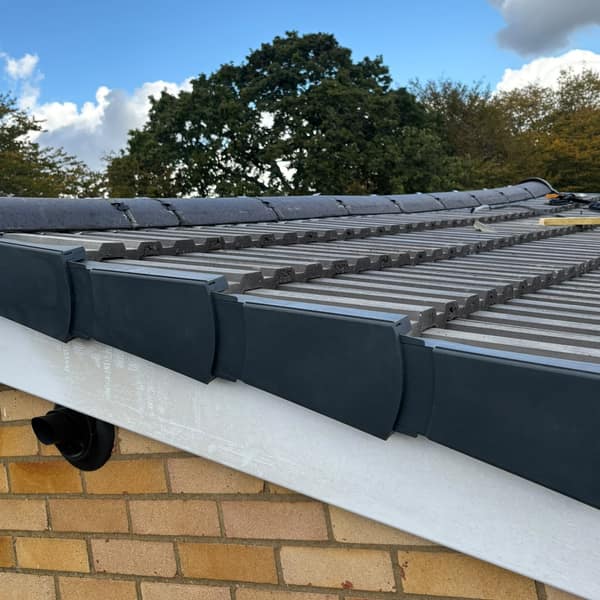Dry verge caps along the edge of the new roof tiles, with a white bargeboard below