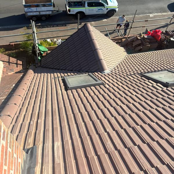 The re-tiled roof from above, with two roof windows and the Dexters Build pickup and trailer in the street