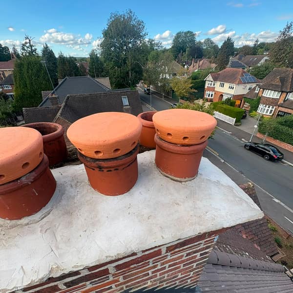 Chimney pots and cowls, with the rooftops of Watford behind