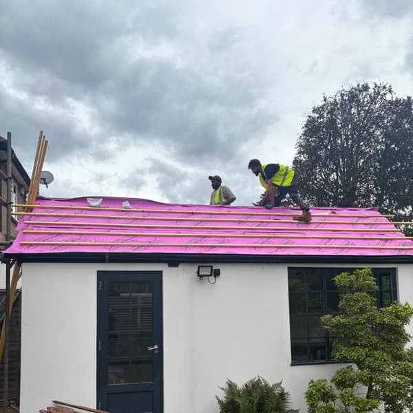 Old clay tiles stripped off the garden building, with new membrane on the roof
